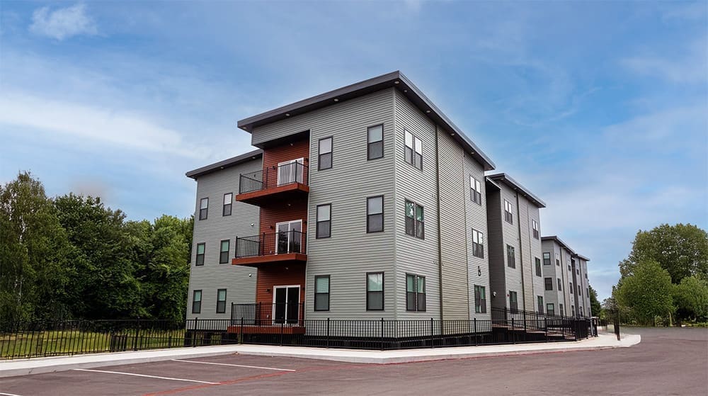 Apartment building with balconies and a parking lot